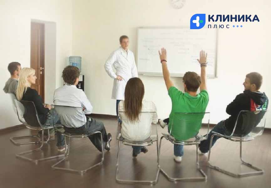 Аудитория с людьми, сидящими на стульях